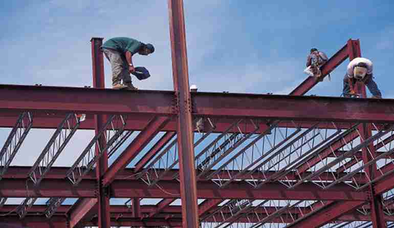 Ironworkers secure beams on a high-rise in Atlanta. Expert welding services for strong structures.